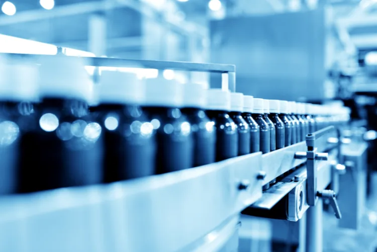 Pharmaceutical production line with containers moving through an automated conveyor system