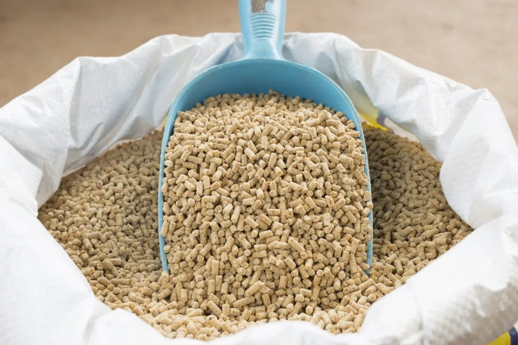 Scoop in a bag of animal feed pellets for specialty ingredient processing